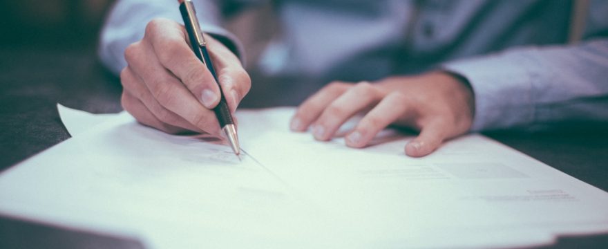 Close-up of a man signing some paperwork