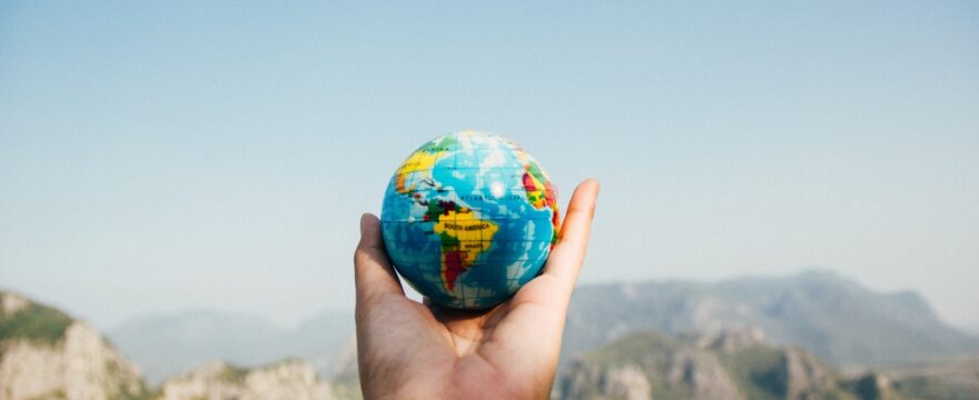 image of a hand holding a small globe